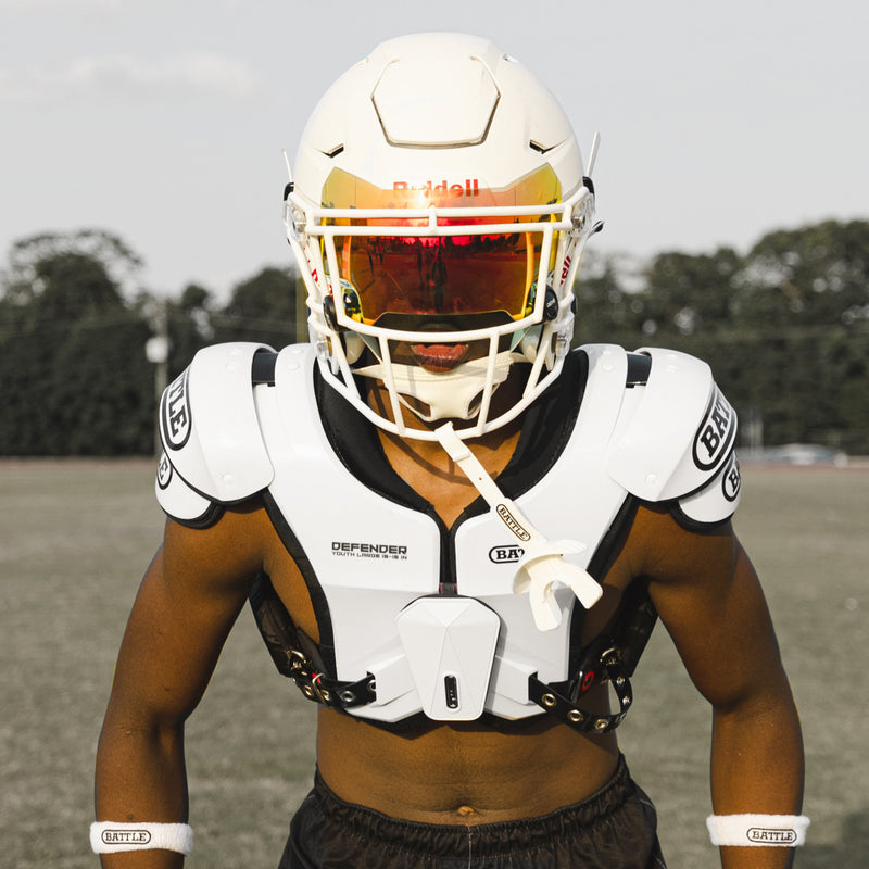 Athlete wearing white Battle Defender Youth shoulder pads on the field