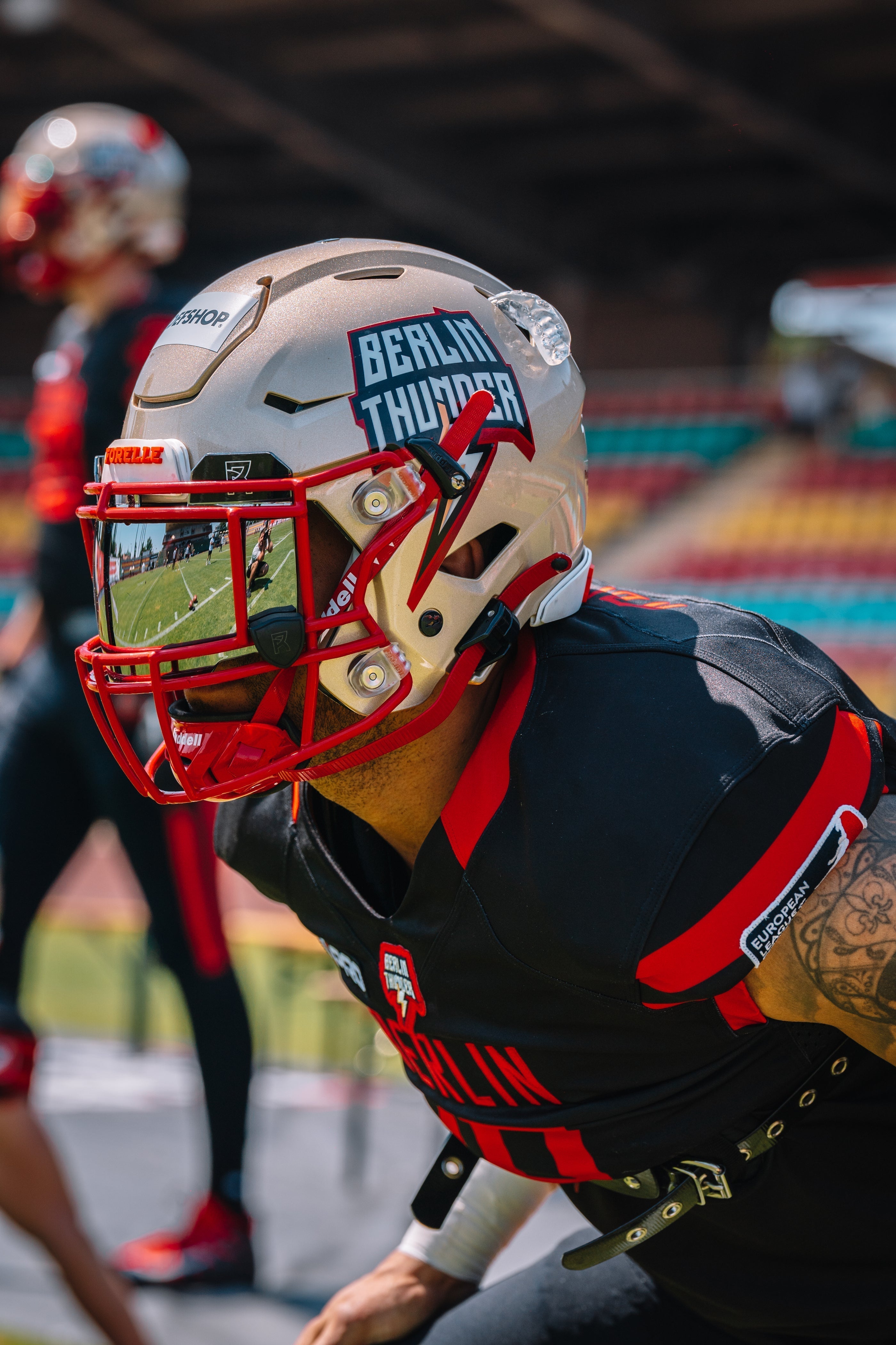 Football player wearing a Berlin Thunder helmet with a red colored visor during a game in the Superserien